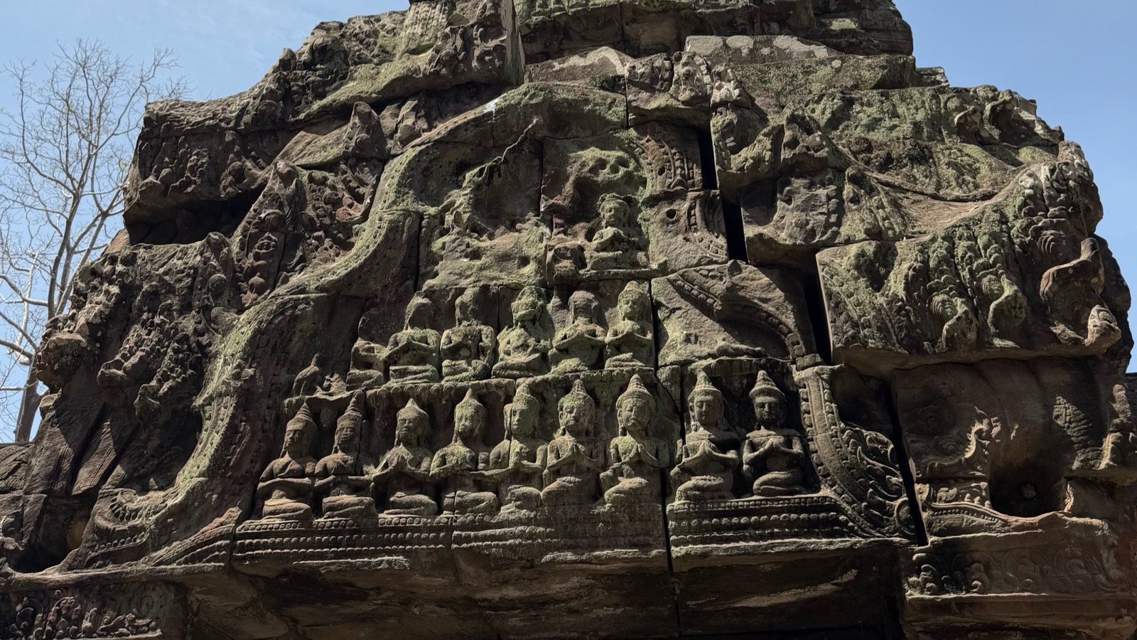 Carved stone devatas on a temple gopura at Ta Prohm, Angkor, Cambodia