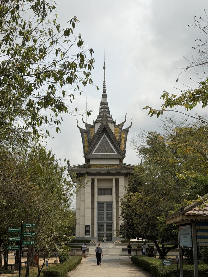 The memorial stupa at Choeung Ek seen down a tree-lined path