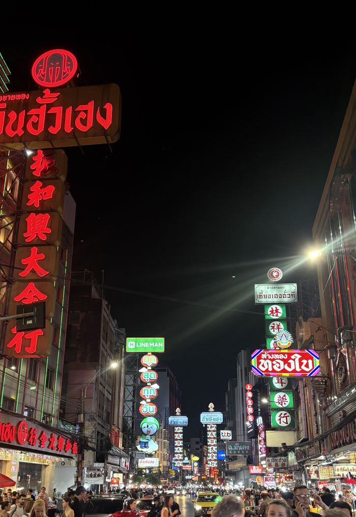 Red and gold neon signs over a Chinatown street at night