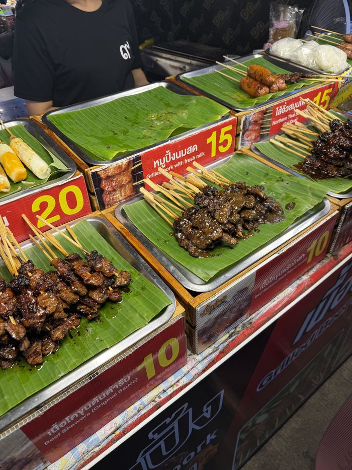 Grilled skewers on banana leaves at a night market stall
