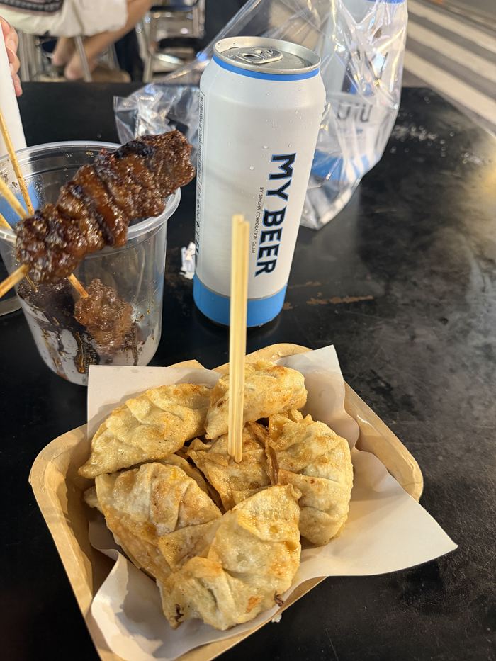 Fried dumplings, a grilled skewer, and a can of beer
