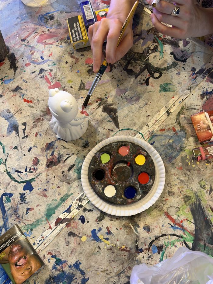 Painting a small Hello Kitty figure with a palette of paints
