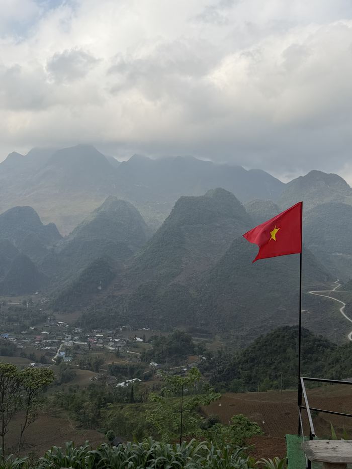 A Vietnamese flag on a hilltop above the mountains