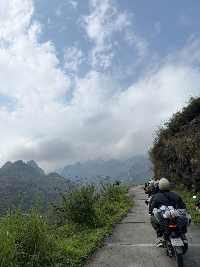 A motorbike on a narrow road along the mountainside