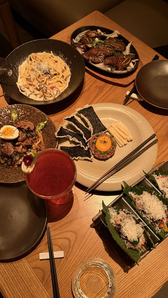 Shared plates and drinks on a restaurant table at night