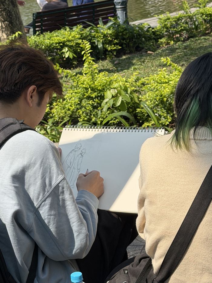 Two people sketching outdoors