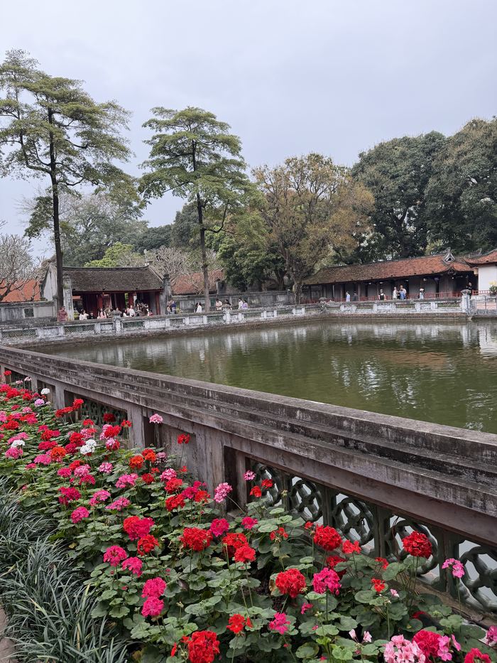 A walled pond lined with red flowers at the Temple of Literature