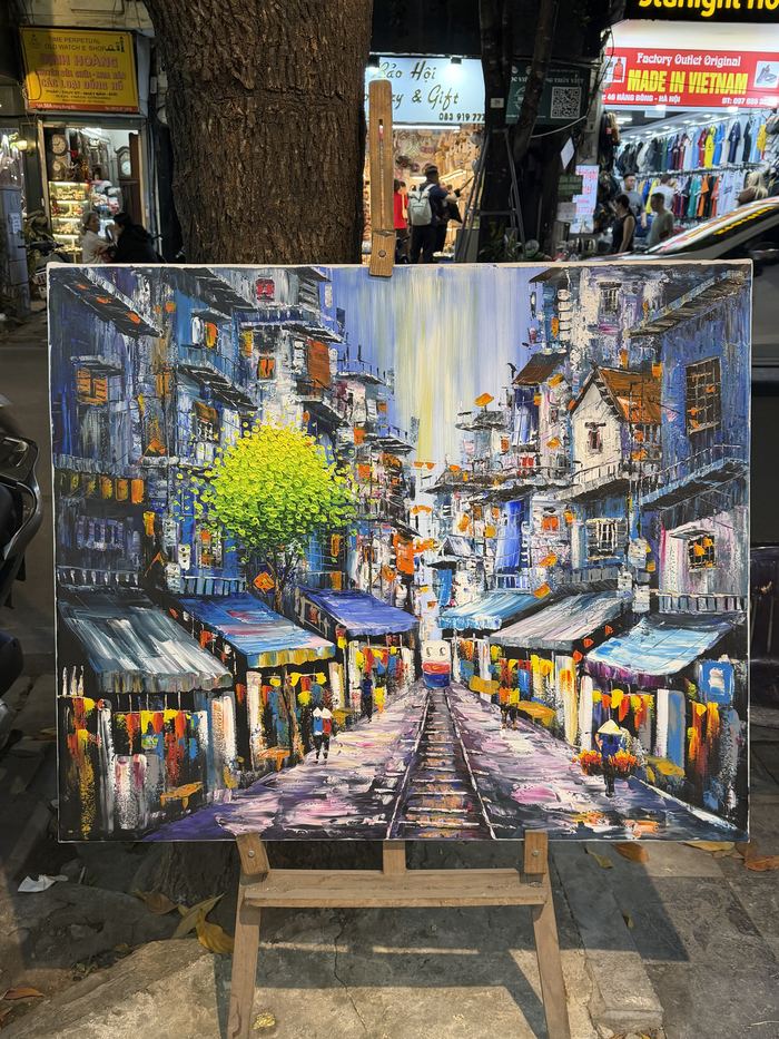 A painting of Hanoi's Train Street on an easel