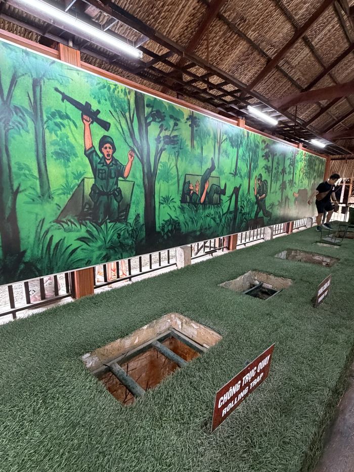 Pit traps on display with a jungle mural behind them