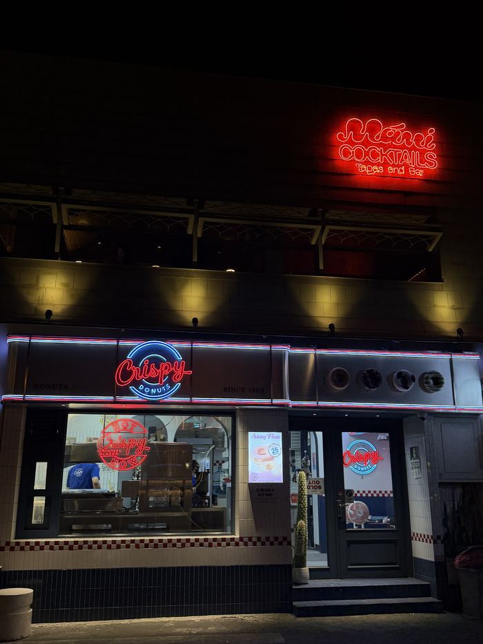 A neon-lit donut shop at night