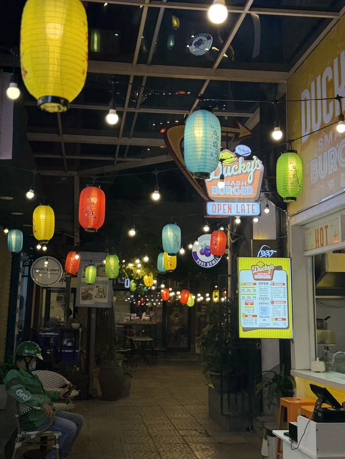 An alley hung with paper lanterns at night