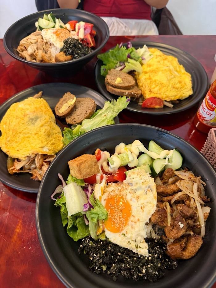 Rice bowls with omelette, salad, and grilled meat