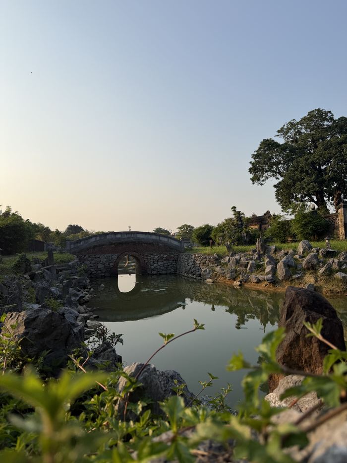 A small stone bridge over a pond