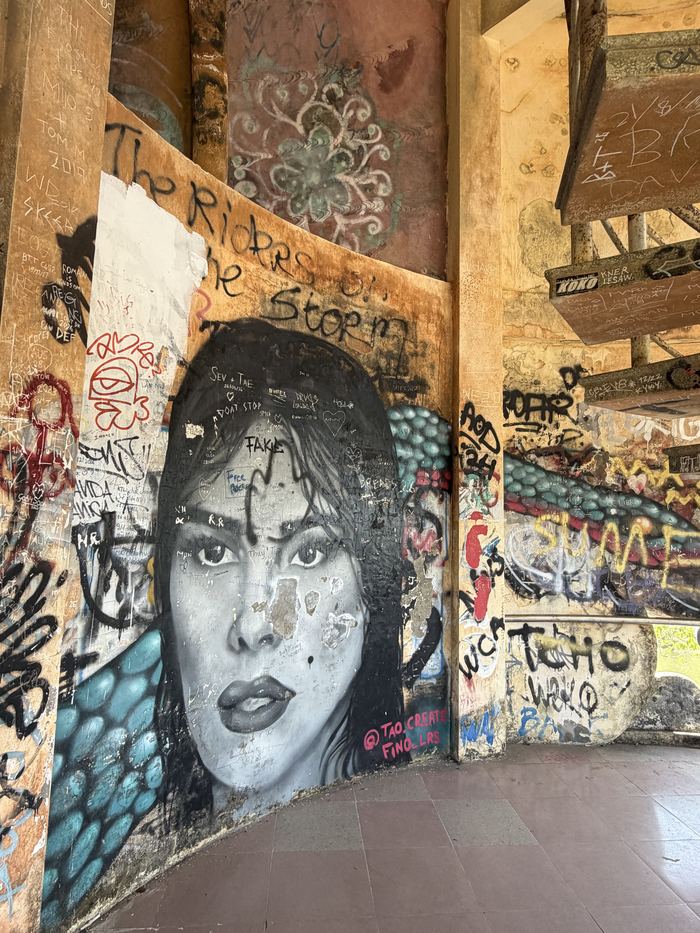 A large graffiti portrait of a woman on a curved wall