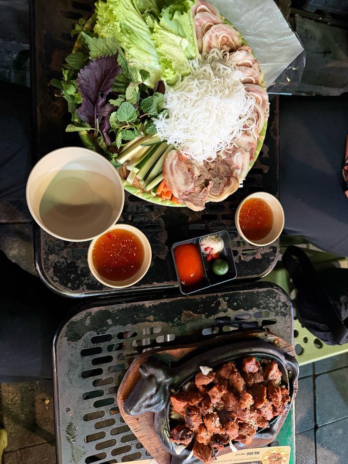 Sliced pig ear with herbs and a plate of grilled chicken
