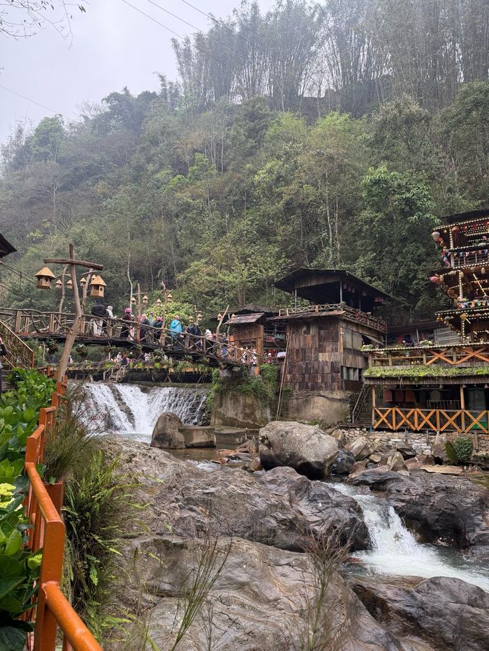 A waterfall below wooden houses in Cat Cat Village